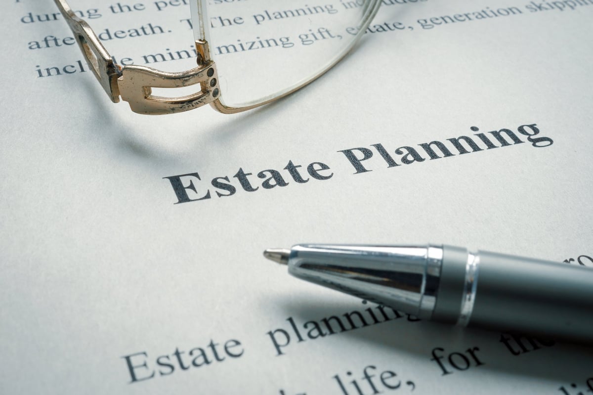 Estate planning documents and glasses on a desk